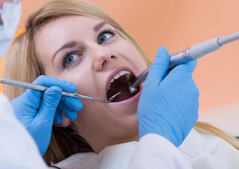 Dentist treating a woman’s teeth in the dental chair